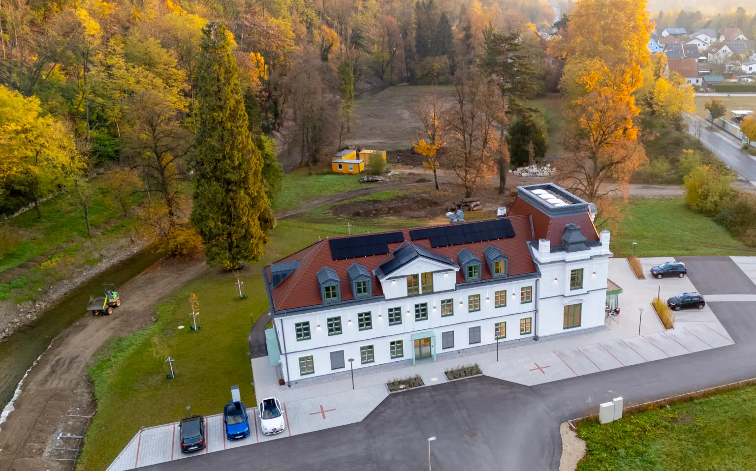 Luftaufnahme im Sommer — die Villa eingebettet in den bewaldeten Hang und den Park