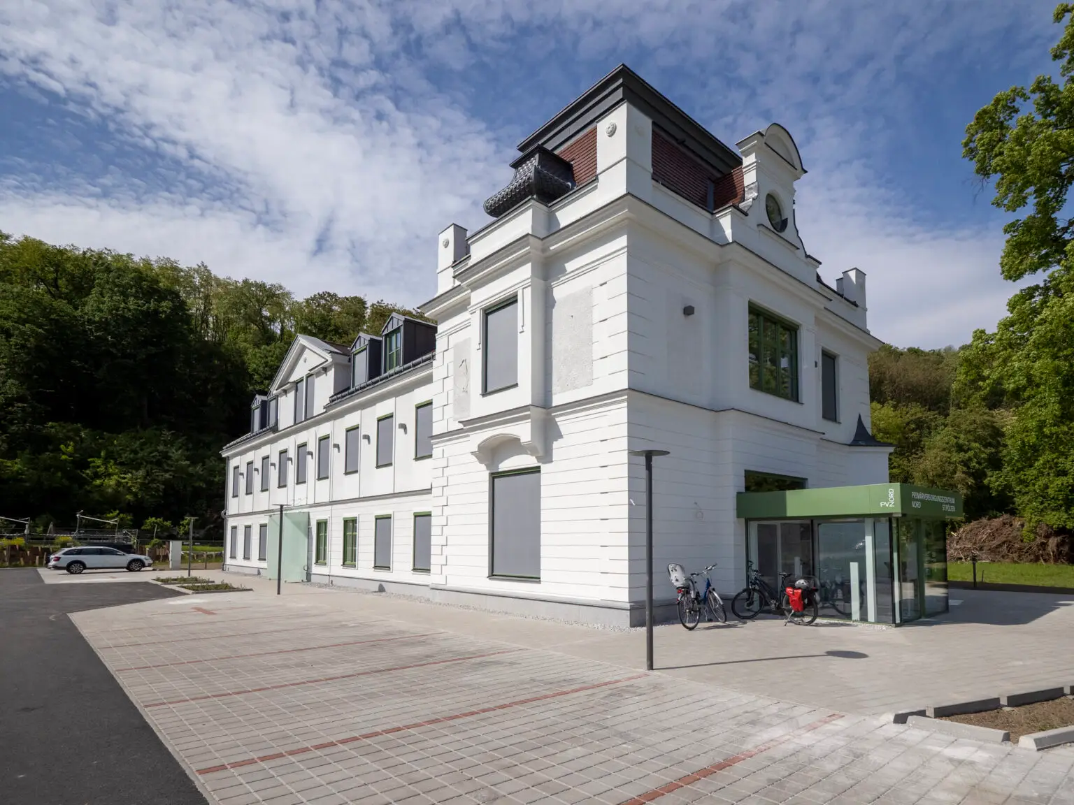 Außenaufnahme der Gebäudeecke — Turmaufbau, Rundfenster, gegliederte weiße Fassade